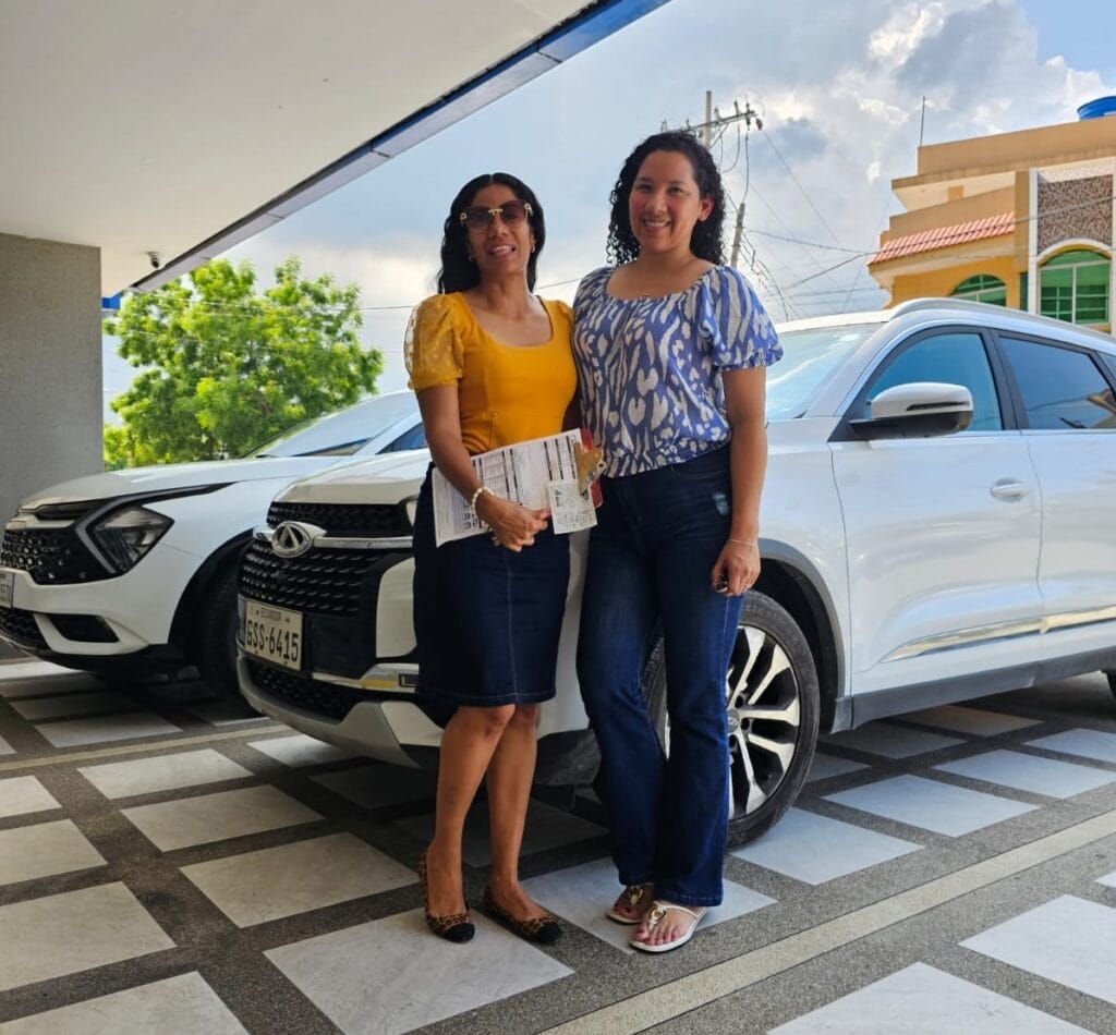 alquiler de carros, Blog, Cliente recibiendo las llaves de un auto de alquiler en Guayaquil, con furgonetas y carros disponibles al fondo.